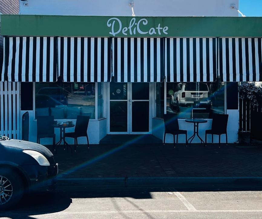 DeliCate Cafe storefront with black and white striped awning and alfresco seating, Henry Street St George QLD