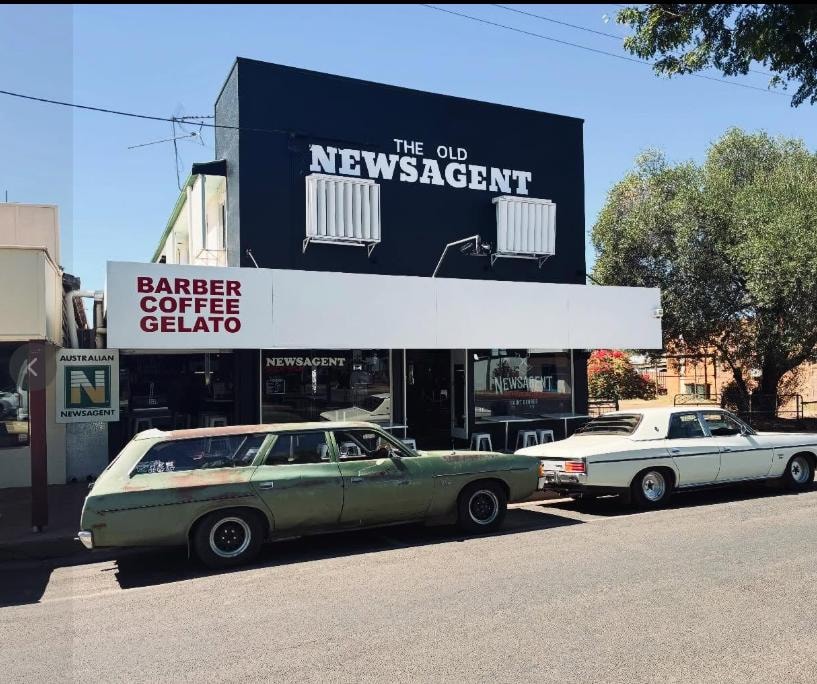 The Old Newsagent storefront with vintage cars parked outside, St George QLD