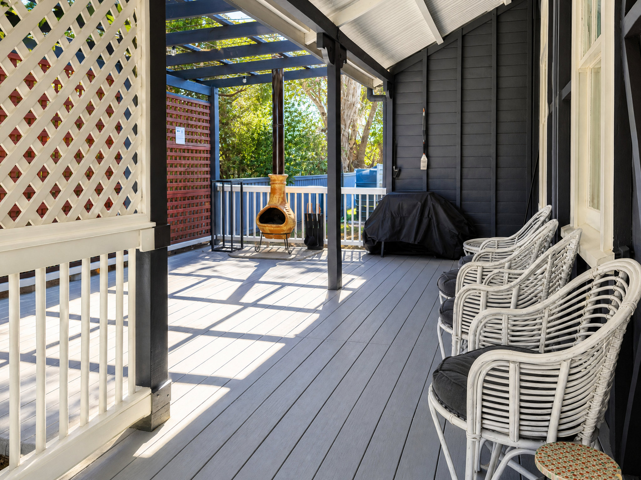 Side deck with chiminea and rattan chairs at Little Anchorage