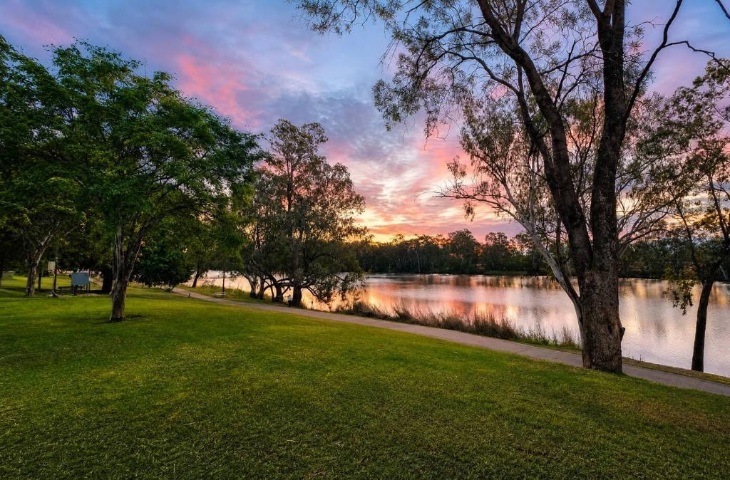 Balonne River walk at sunset, St George QLD — green lawns, gum trees and pink sky